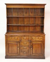 A French provincial pitched pine, elm and oak dresser, having two-tier boarded plate rack over