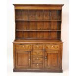 A French provincial pitched pine, elm and oak dresser, having two-tier boarded plate rack over