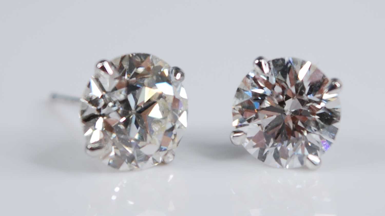 A pair of Edwardian platinum diamond set ear studs, each being Old European cut stones, in four-claw