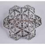 A modern 18ct white gold and diamond set snowflake brooch, of openwork convex form, centre set