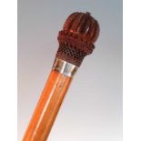 An early 20th century walking stick, having an ornately carved yew handle and white metal collar