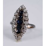 An Edwardian yellow metal, sapphire and diamond dress ring, the large elliptical setting measuring