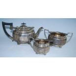 A George V three-piece silver tea set, comprising teapot, twin handled sugar and cream, each piece