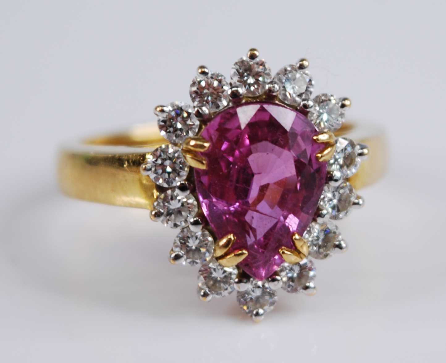 A yellow and white metal, tourmaline and diamond pear shaped cluster ring, featuring a pear cut pink