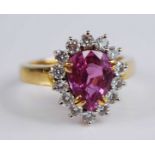 A yellow and white metal, tourmaline and diamond pear shaped cluster ring, featuring a pear cut pink