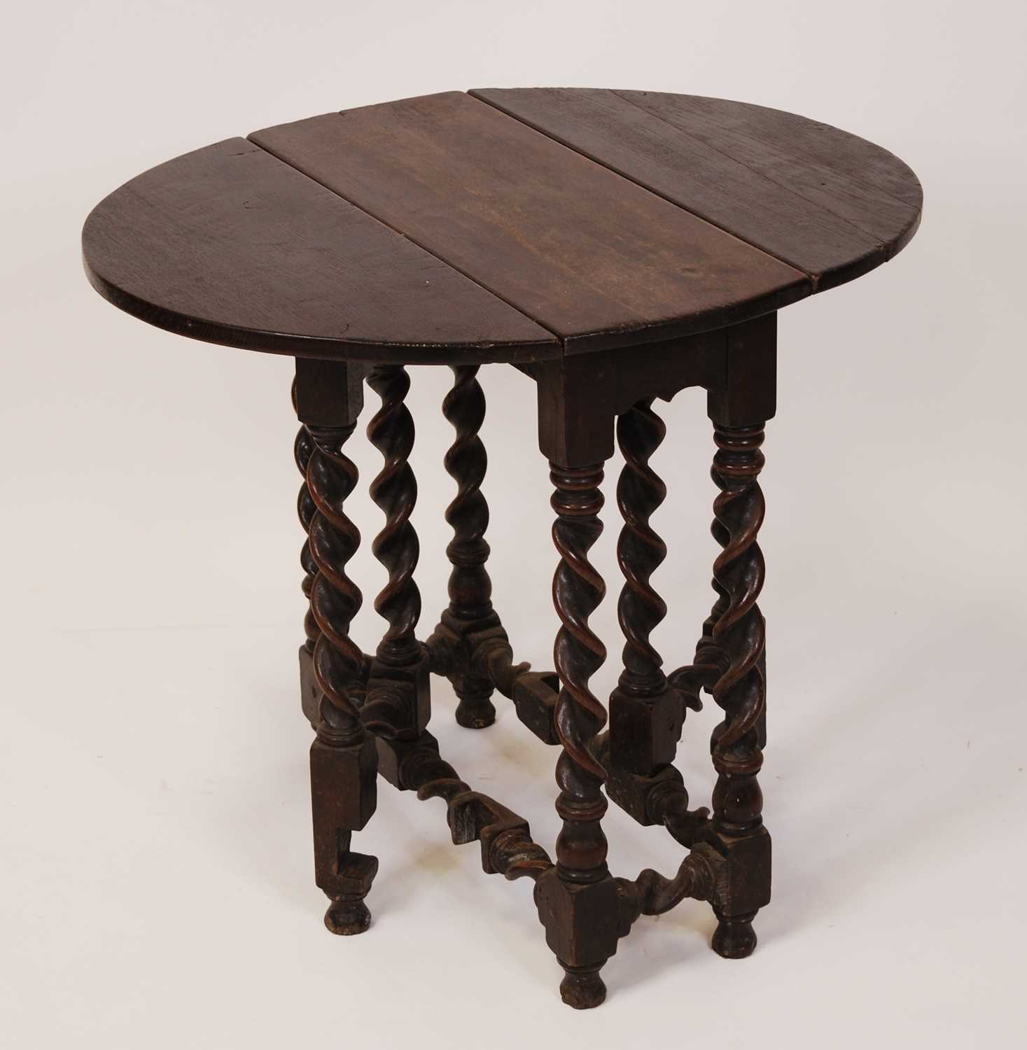 An 18th century provincial joined oak dropleaf occasional table, the oval fall leaves with gateleg