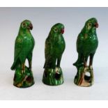 A set of three mid 19th century Chinese green glazed earthenware models of parrots, each shown
