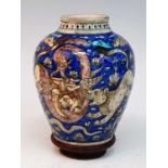 A 19th century Persian Qajar earthenware vase, decorated with fighting animals upon a cobalt ground,