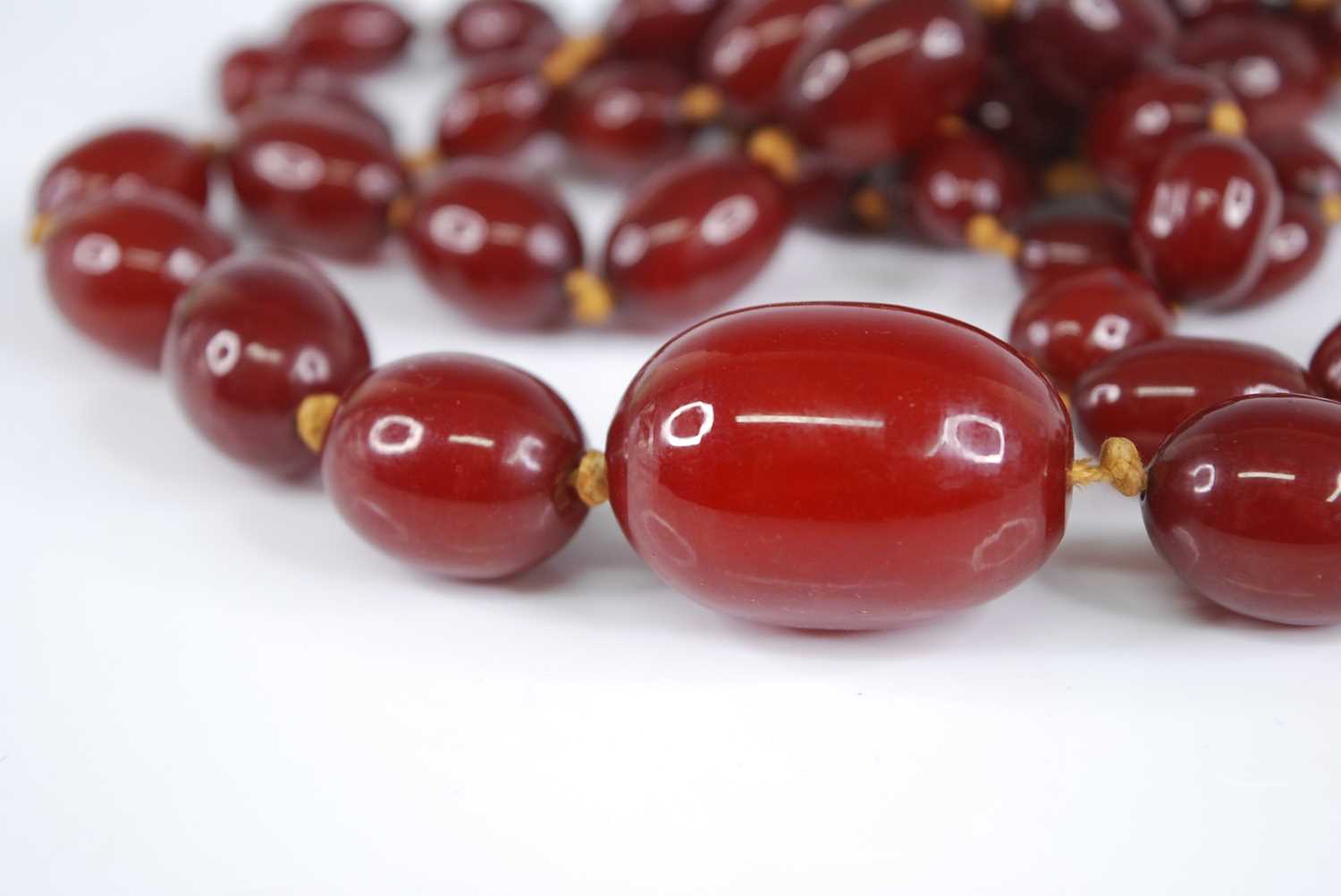 A cherry amber necklace, the 66 graduated barrel beads on a knotted string, gross weight 107g, - Image 3 of 5