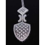 A white metal diamond articulated shield shaped pendant, having 106 melee cut diamonds grain set