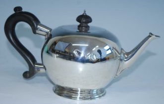 A George V silver bachelors teapot, of bullet form with straight cast spout and S-scroll ebonised