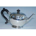 A George V silver bachelors teapot, of bullet form with straight cast spout and S-scroll ebonised