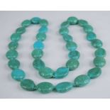 A turquoise necklace, comprising 34 oval stones on a knotted string (most with numerous fractures