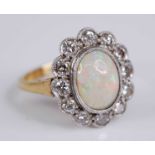 An 18ct gold and platinum, opal and diamond set cluster ring, arranged as a central opal cabochon
