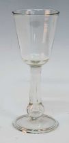 A large Georgian wine glass, the round funnel bowl above a teared baluster stem and folded foot, h.