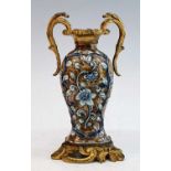 An 18th century tin glazed earthenware vase, relief decorated with blue trailing flowers upon a