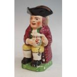 An early 19th century Staffordshire Enoch Wood type 'ordinary' Toby jug, shown holding a foaming