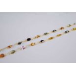 A contemporary yellow metal multi-sapphire necklace, bezel set with 43 oval cut sapphires in a