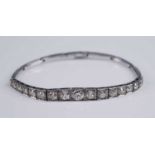 A white metal diamond articulated line bracelet, comprising 17 graduated Old European cut diamonds