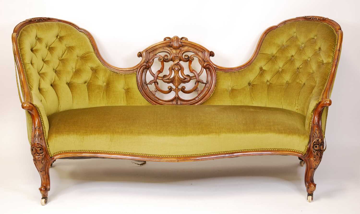 A mid-Victorian walnut and floral carved showframe double humpback settee, having intricate