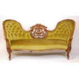 A mid-Victorian walnut and floral carved showframe double humpback settee, having intricate