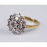 A yellow and white metal diamond circular cluster ring, featuring a centre round brilliant cut