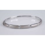 A contemporary 18ct white gold and diamond set hinged bangle, half with six finely brushed gold