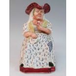 A circa 1830 Staffordshire 'Drunken Sal' Toby jug, probably Davenport, shown seated with a glass