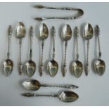 A set of eleven George V silver apostle spoons with matching sugar tongs, having spiral turned stems