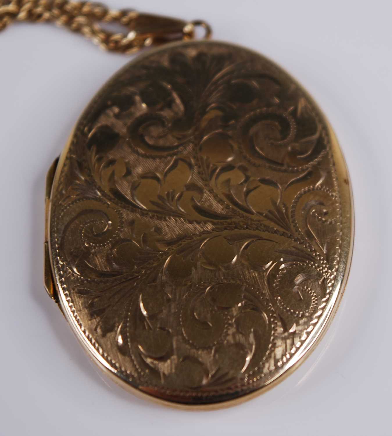 A 9ct yellow gold oval locket, engraved with foliate detail, locket dimensions 42 x 32mm, attached - Image 2 of 3