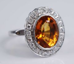 A platinum citrine and diamond oval cluster ring, comprising a centre oval faceted citrine within