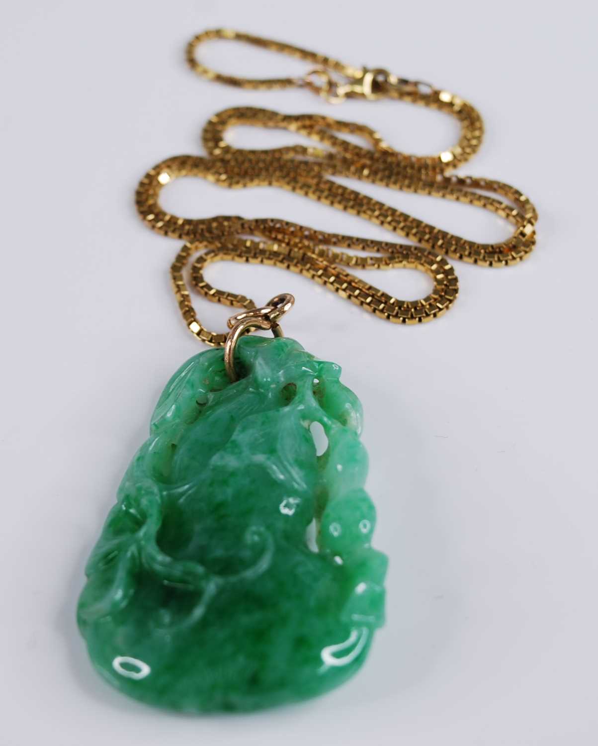 A Chinese carved green and celadon jade pendant, modelled as a gourd issuing leaves and foliage, h.