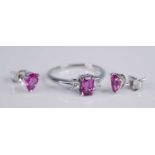 An 18ct white gold, pink sapphire and diamond three stone ring, the four-claw set emerald cut pink