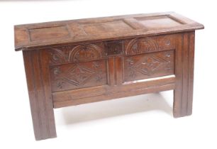 A circa 1700 joined oak coffer, having a three panel top on steel loop hinges, above a two panel