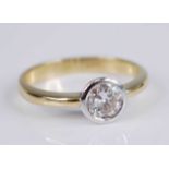 A yellow and white metal diamond solitaire ring, featuring a round brilliant cut diamond in a