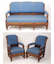 A late Victorian heavily carved oak framed three-piece parlour suite, comprising; three-seater