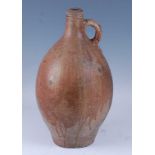 An early 18th century German salt glazed stoneware Bellarmine type flagon, of typical form, having a