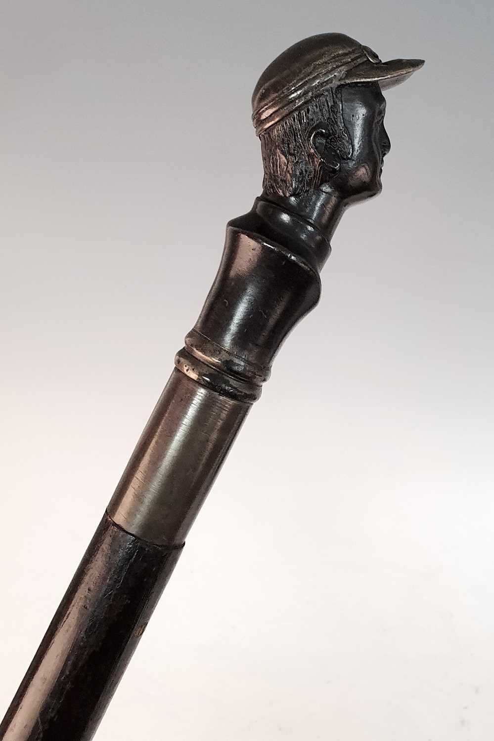 An early 20th century walking stick, the bronze handle in the form of the head of a jockey, - Bild 4 aus 5