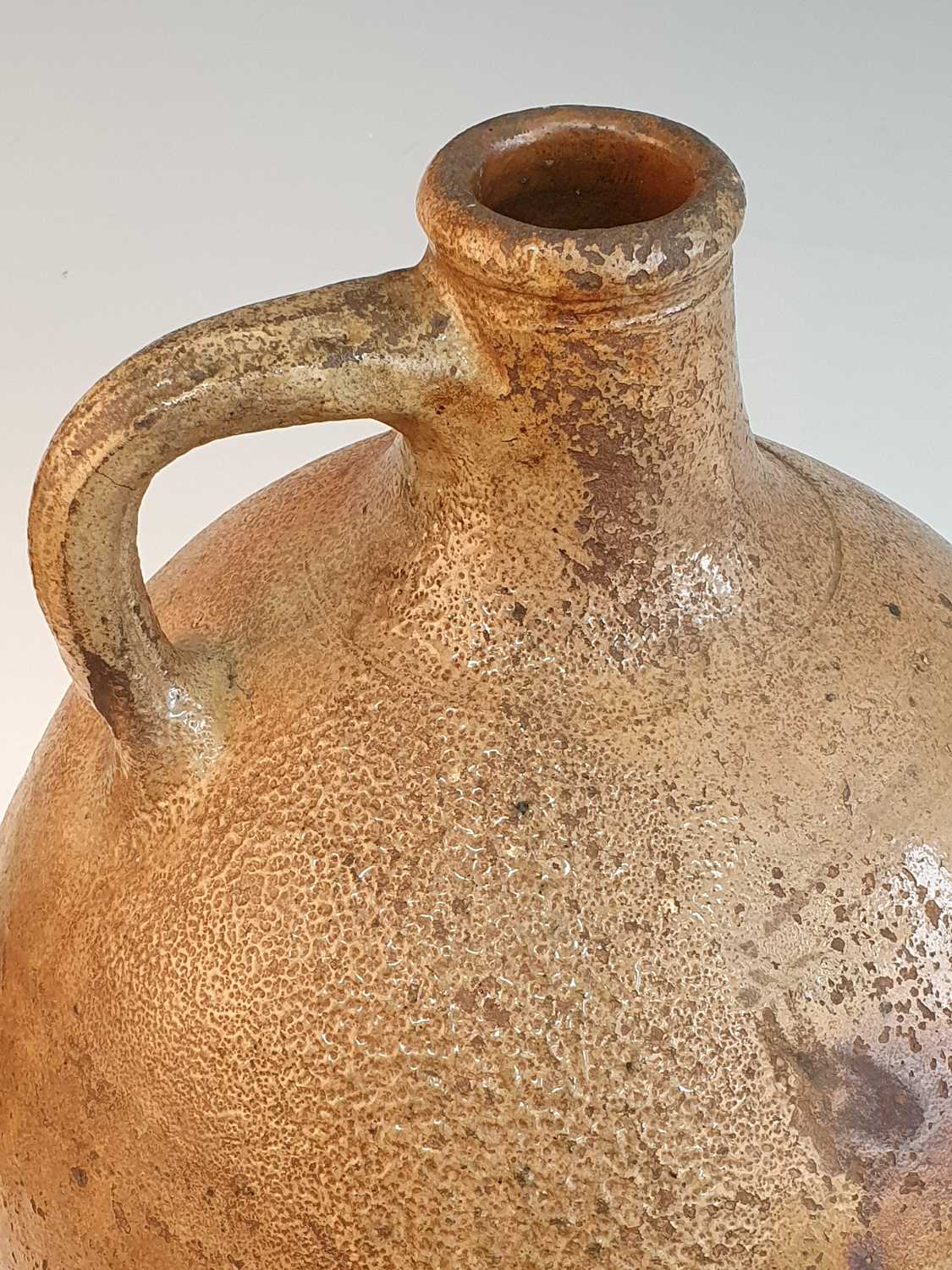 An early 18th century German salt glazed stoneware Bellarmine type flagon, of typical form, having a - Image 6 of 6