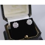 A pair of yellow and white metal diamond circular cluster stud earrings, each with nine round