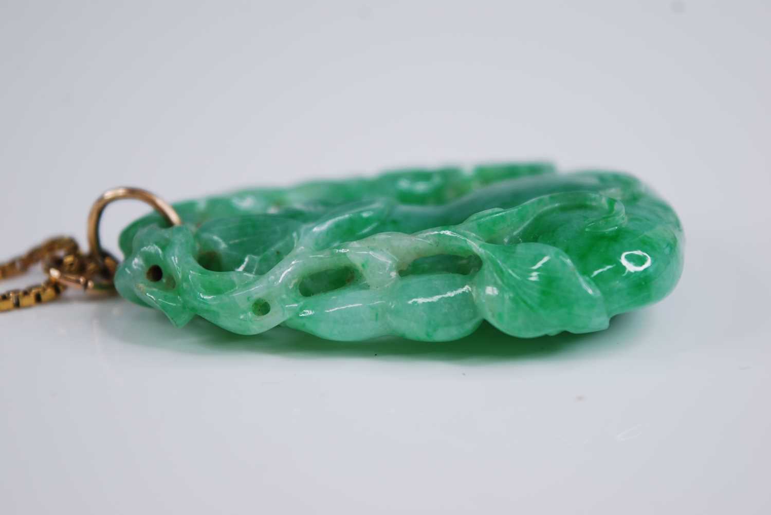 A Chinese carved green and celadon jade pendant, modelled as a gourd issuing leaves and foliage, h. - Image 5 of 7
