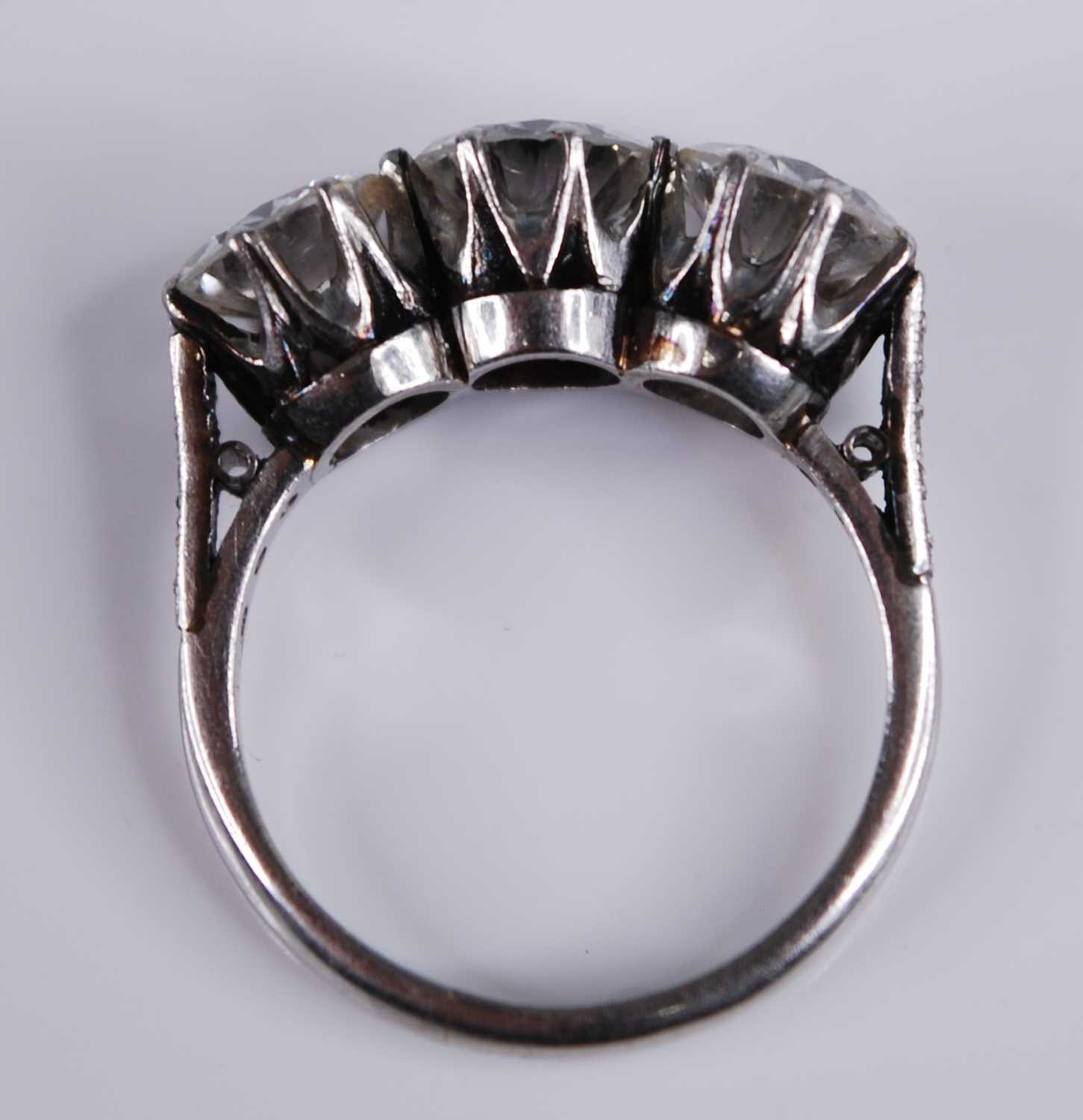 A white metal diamond three stone ring, comprising three round brilliant cut diamonds in claw - Image 7 of 7