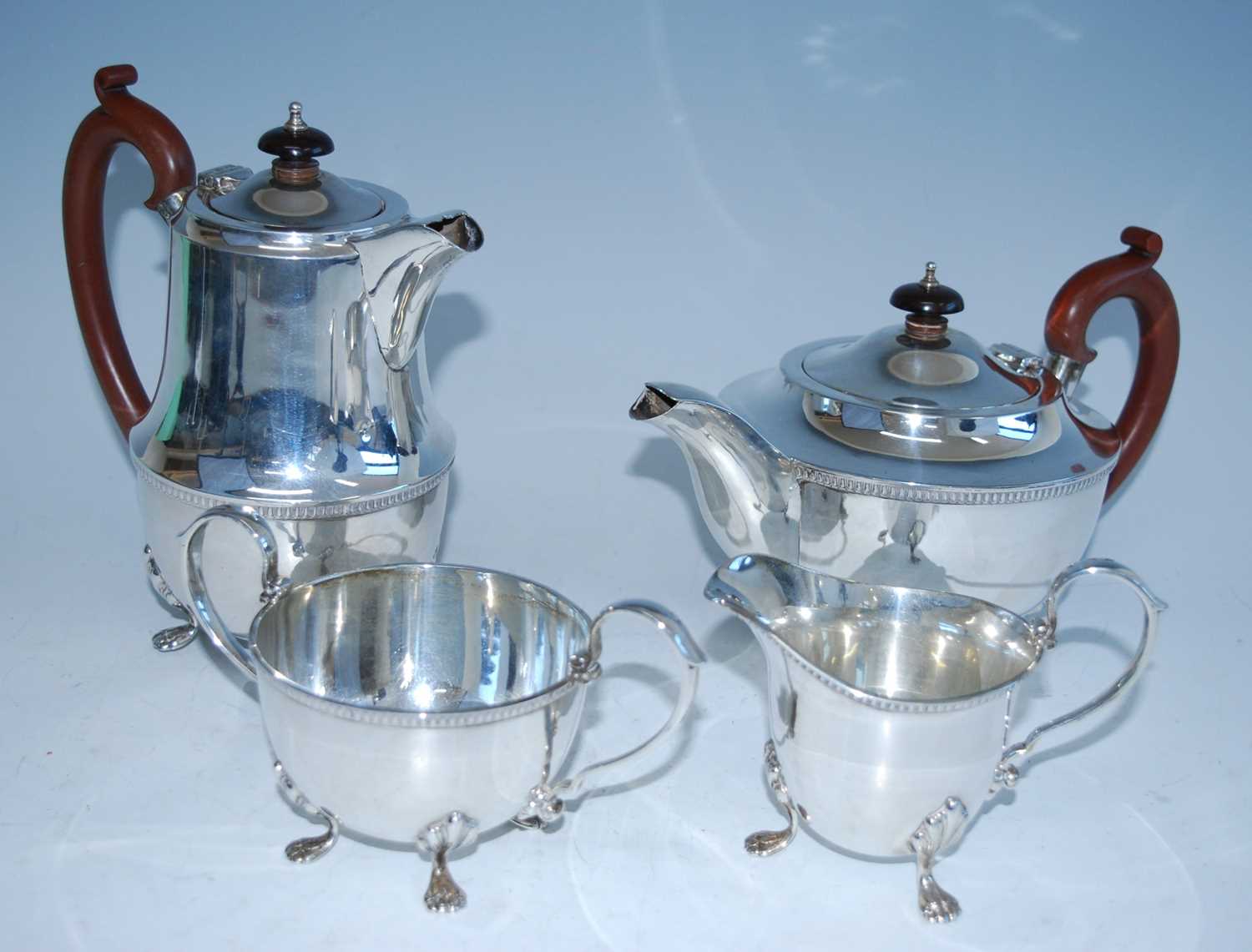 A mid-20th century silver four-piece tea set, comprising teapot, hot water pot, sugar and cream,