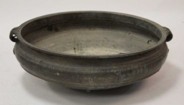 A large Chinese brass twin handled shallow bowl, of slightly shouldered squat form with floral