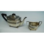 An Edwardian silver teapot and sugar duo, each of shaped oblong form with banded decoration and