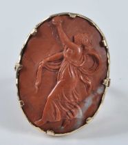 A yellow metal oval lava stone cameo ring, depicting a female figure in classical dress, with