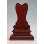 A 19th century mahogany charger stand, the shaped back above an ogee moulded base, h.32cm