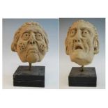 Two carved sandstone heads, probably 17th century, each later mounted upon a polished slate base,