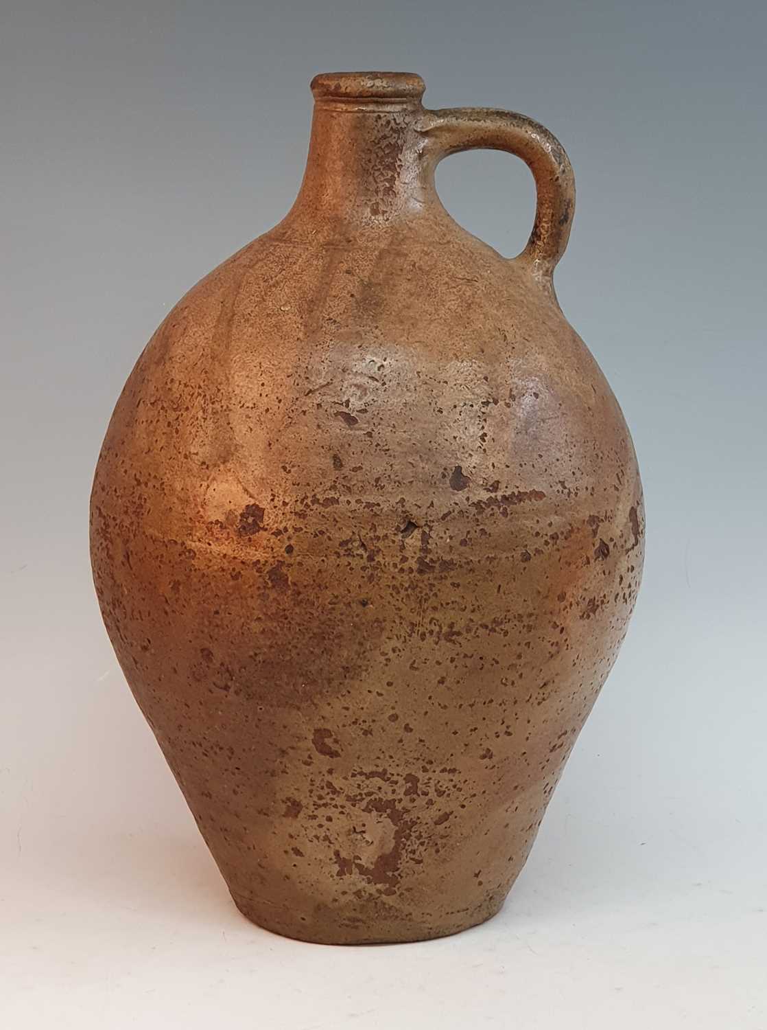 An early 18th century German salt glazed stoneware Bellarmine type flagon, of typical form, having a