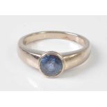 An 18ct white gold sapphire dress ring, the round faceted sapphire in a bezel setting, sapphire